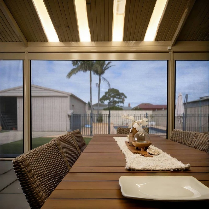 Long dining table looking out through floor-to-ceiling patio screens.