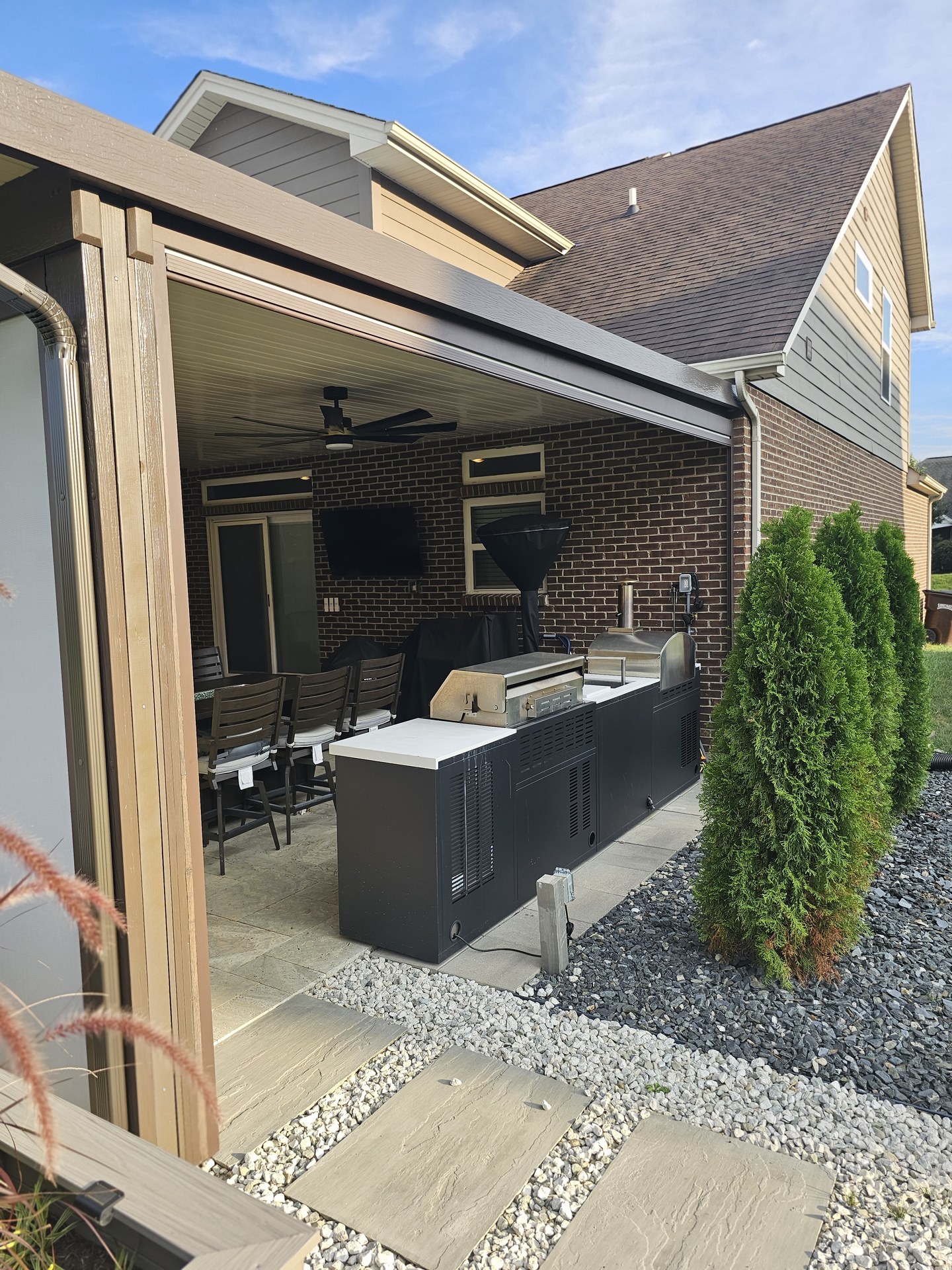 Finished outdoor living room with motorized screens looking out to the yard.